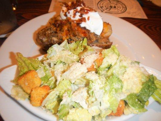 Loaded pulled pork baked potato and Caesar side salad.