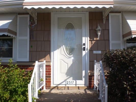 Decorative insulated fiberglass door with extruded aluminum storm door.