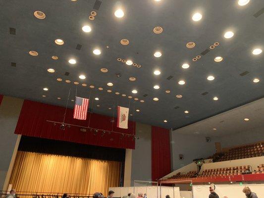 Inside the main auditorium, seated in the post-shot waiting area. All chairs sanitized after each use.