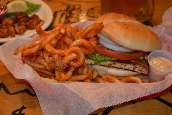 Dive into flavor with our sizzling Blackened Mahi Fish Sandwich and curly fries!