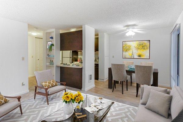 Staged living room, dining and kitchen area featuring hard surface flooring and access to a private patio or balcony.