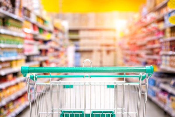 A shopping basket rolling down a single isle in the grocery store.