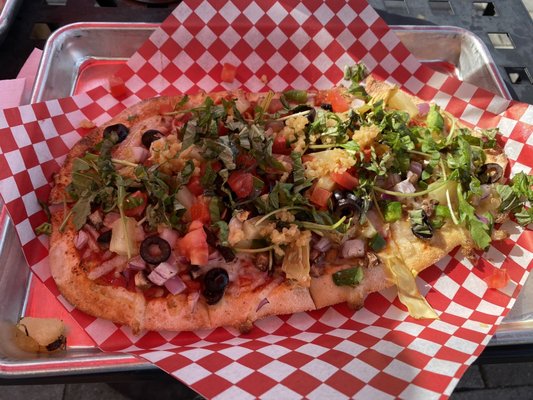 Personal pizza with vegan cheese and a bunch of veggies