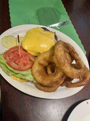 Cheese burger on an English muffin, lettuce, tomato and onion rings