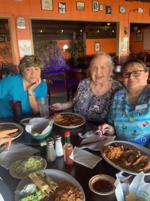 Two of DG Comfort Home Care's caregivers enjoying lunch with our beloved client, Linda