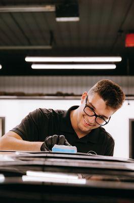 Cole McClure applying ceramic coating to a vehicle after a paint correction.