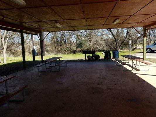 Pavilion with bbq pit picnic tables and lighting.