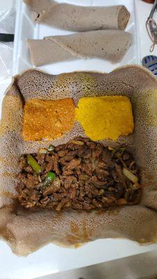 Beef Tibs with lentils and yellow split peas on Injera.