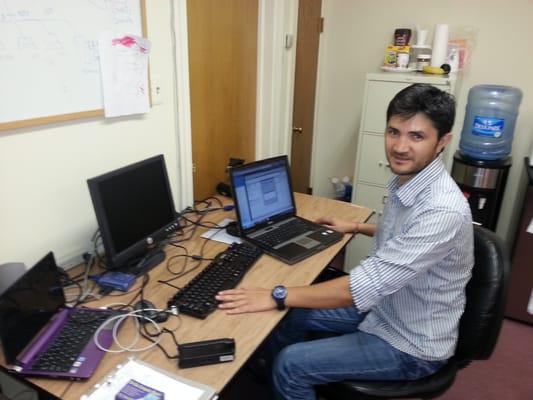 Raul working on a computer in our office