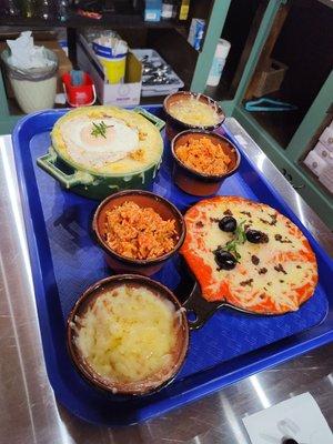 Red enchilada with ground beef, green enchilada with over easy egg, rice and beans