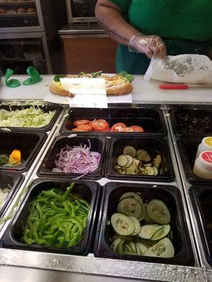 Dominique is preparing my chicken bacon ranch sub. I like the production line with so many choices of fresh vegetables