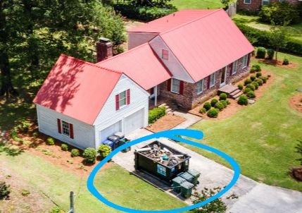 Dumpster placed perfectly on left side of driveway.