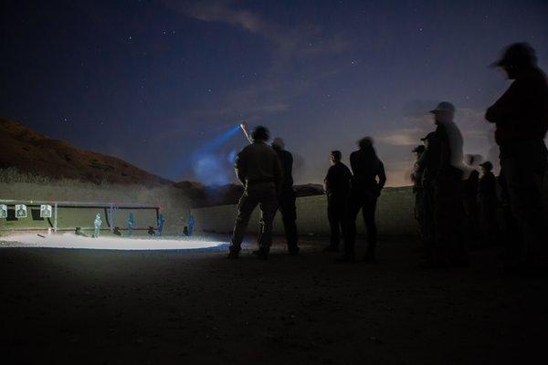 Low-light training on steel targets practicing independent flashlight techniques.