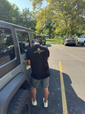 Bott locksmith opening a jeep wrangler for a customer.