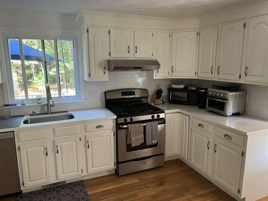 Newly installed white quartz countertop and tile backsplash