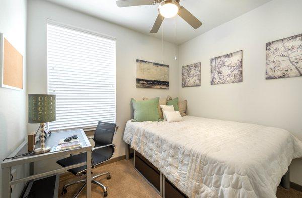 Bedroom equipped with desk, dresser, and bed