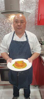 Holding a plate of stuffed red peppers with orzo pasta, romesco sauce, and herb oil