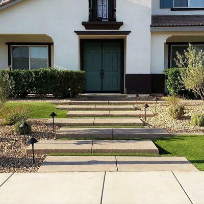 Floating, stamped concrete entry steps surrounded by EasyTurf artificial lawn and desertscape planters offer year- round curb appeal.