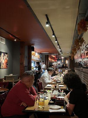 Narrow dining area with tables and bar seating