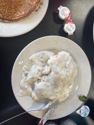 Biscuits and gravy with a n extra pancake and eggs