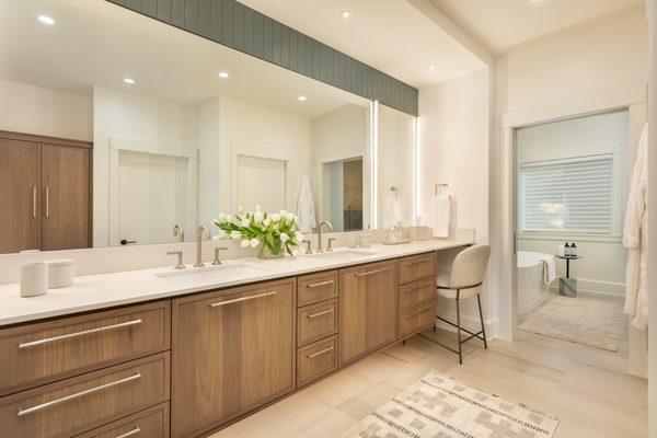 Custom Master Bath with bleached walnut floating cabinetry, large format tile, LED lighting, and Caesarstone countertops.