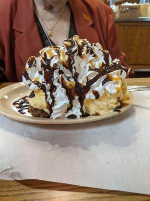 Impressive warm Brownie covered in ice cream topped with real whipped cream drizzled with chocolate sauce