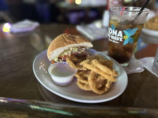 Half of a buffalo chicken sandwich and onion rings