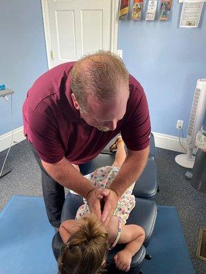 Dr. James T Sheneman manually adjusting one of our ChiroKids at Clinton Chiropractic Wellness Clinic & Absolute Pain Free Laser Center