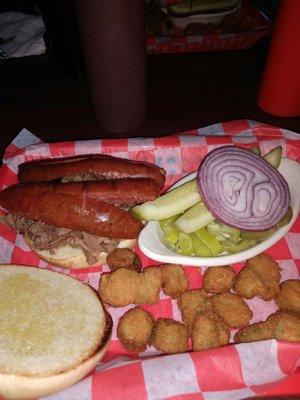 Chopped beef sandwich topped with hot link sausage, okra and all the fixins