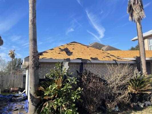 Old shingles being removed from detached garage roof.