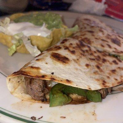 Fajita Quesadilla - One large cheese quesadilla stuffed with grilled peppers, onions, and grilled chicken. Garnished with shredded lettuce,