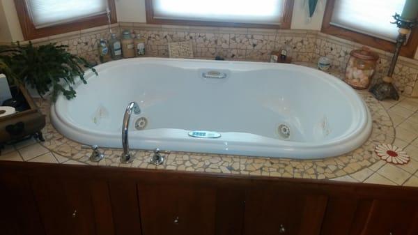 Jet tub installation surrounded by a custom tile deck with a Teak front.