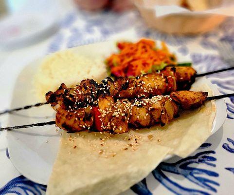 Chicken Souvlaki. Grilled chicken skewers with red pepper and onions. Served with white rice & carrot-red cabbage slaw.