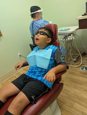 Don't mind his face! He loves watching the movies while getting his teeth cleaned.