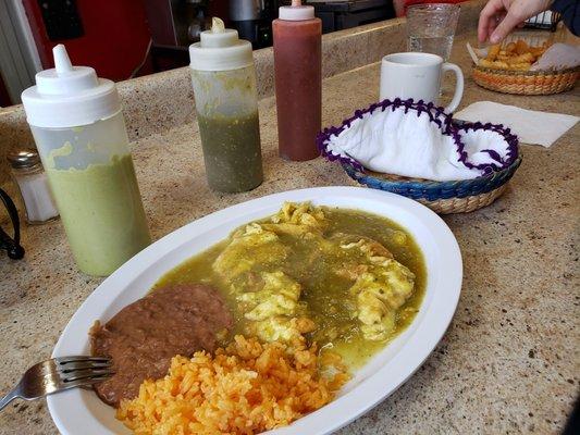 Huevos en salsa verde with homemade tortillas de maíz on the side. Three salsa options, french fries.