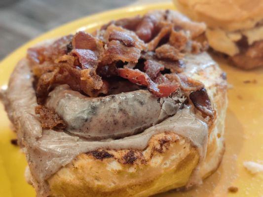 Cinnamon roll with bacon crumbles on top.