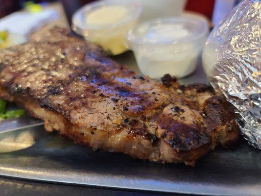 Charcoaled New York strip seasoned with a rub.