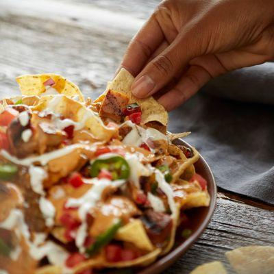 Nachos can be loaded with grilled adobo chicken, house-made pico de gallo and QDOBA's signature 3-cheese queso, free on any e...