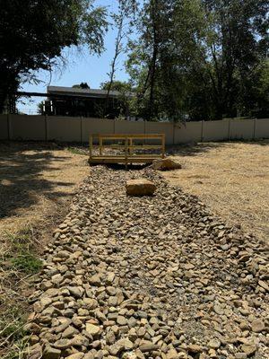 Dry creek bed with a wooden bridge