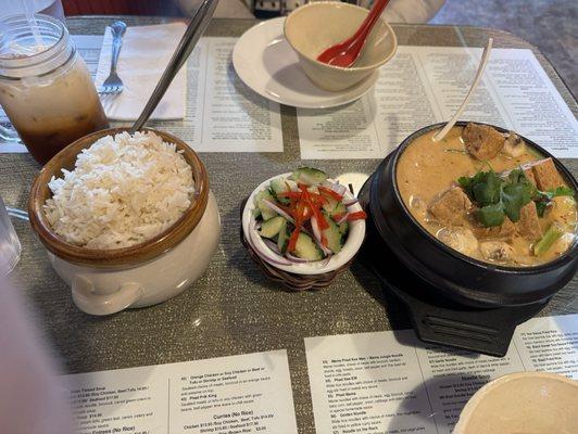 Tom Kha, rice, cucumber salad, thai ice tea and water in crystal glass bottle.