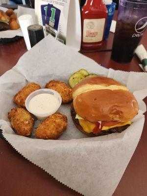 A cheese burger with jalapeño poppers.