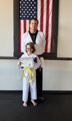 My daughter receiving her purple belt from Master Paul