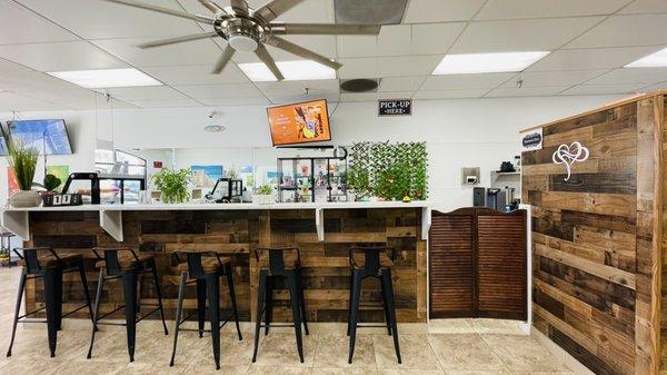 View of the bar with additional seating. Register and entrance are to the left.