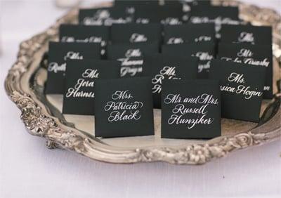 White Hand-Calligraphered table cards on black envelopes by Black Ink.