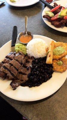 Parilla Mojito; citrus-marinated steak served with rice, black beans, fried yuca, tostones, guasacaca.