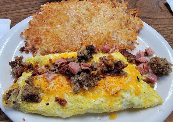 Meat lover's omelet with hash browns.