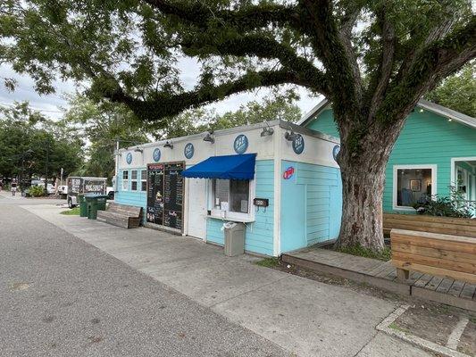 Pop Shop and to the right is a place to sit and eat beneath the shade of the tree.