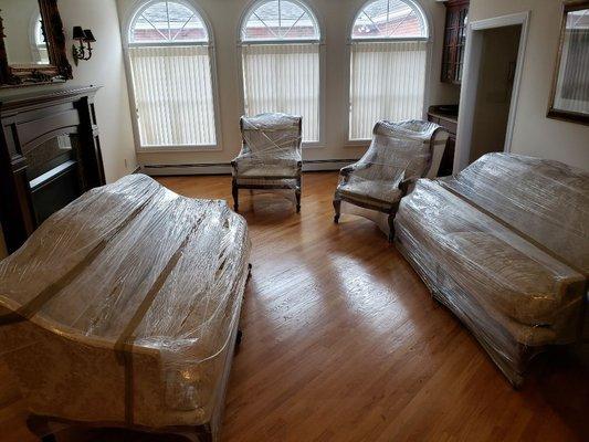 Antique living room set shrink wrapped for storage.