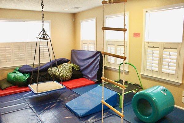 Padded sensory gym area with swings.