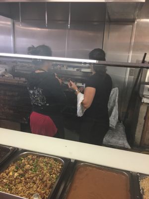 These ladies are seasoning the meat while it turns over the coals